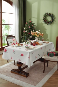 Detailed close-up of festive Christmas tablecloth featuring red berries and snowflakes