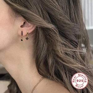 Detailed close-up of 925 sterling silver gold-plated clover earrings worn by a model