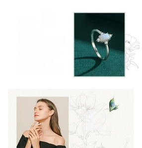 Detail of silver opal ring featuring a rectangular white stone and diamond accents