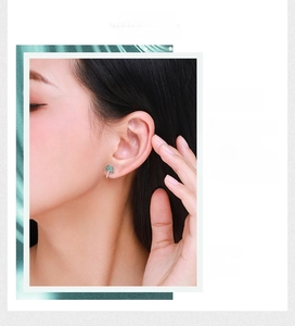 Gros plan d'un clou d'oreille palmier serti de cristaux verts et blancs sur un mannequin