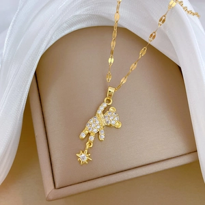 Macro shot of gold titanium necklace featuring a bear pendant with white zircon stones