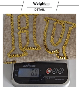 Detailed weight measurement showing a 60g burlap Christmas stocking with gold JOY sequins