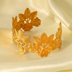Detailed view of 18K gold branch and rose flower relief on a stainless steel cuff bracelet