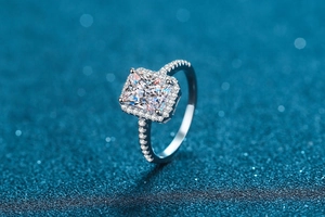 Macro shot of a radiant cut square stone engagement ring with halo and pavé setting