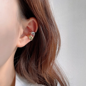 Close-up of gold and silver S925 sterling silver ear cuffs on a model ear
