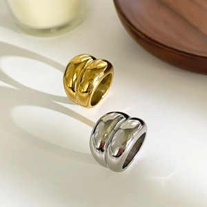 Macro view of wide curved titanium steel rings in polished gold and silver finishes