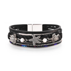 Detailed view of multilayer leather bracelet with silver sea turtle and starfish charms