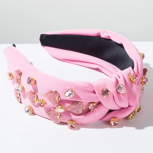 Detailaufnahme rosa Knoten-Haarreif mit glitzernden Herz-Applikationen und Strasssteinen