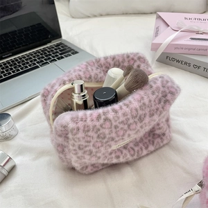 Pink leopard plush cosmetic bag with zipper storing brushes and skincare bottles