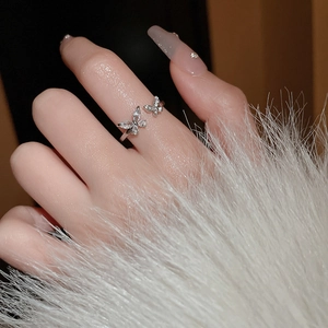 Detailed view of silver butterfly ring with cubic zirconia stones on a plush background