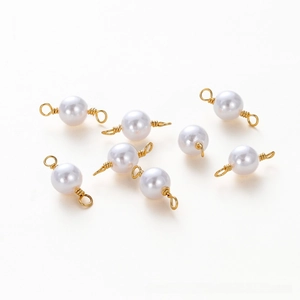 Close-up of 8 white pearls with 18K gold plated wire loops for DIY jewelry making