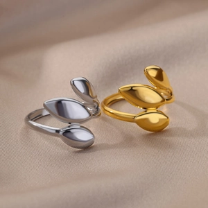 Macro view of adjustable leaf-shaped rings in polished gold and silver finishes