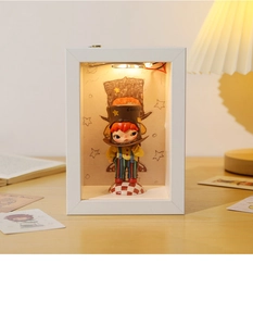 Detailed 3D shadow box with warm LED lights and character doll in white wood frame