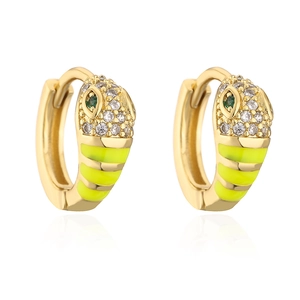 Macro shot of 18K gold snake earrings with green zircon eyes and neon yellow enamel