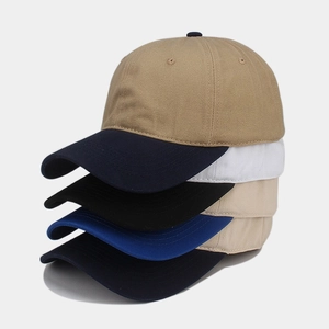 Vertical stack of five colorful cotton baseball caps showing textures and curved brims