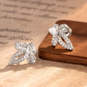 Silver bow and heart shaped stud earrings with clear zircon on vintage book pages