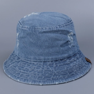 Détail du chapeau bob en jean délavé avec bords effilochés et petite étiquette en cuir
