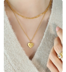Dettaglio della collana a doppio strato dorata con pendente a cuore e stella su un modello
