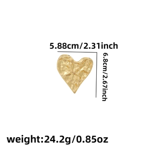 Detail of gold heart brooch showing dimensions 5.88x6.8cm and hammered metal texture