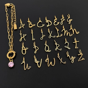 Complete set goudkleurige titanium stalen A-Z letterbedels en een roze edelsteen armband.