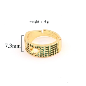 Detail of gold snake ring featuring green zircons and side heart cutout design