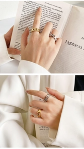 Detalle de anillos de cadena ajustables en oro y plata en los dedos de una modelo