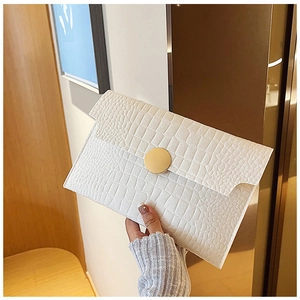 Detailed view of white crocodile pattern envelope clutch with golden round metal buckle
