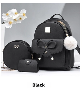 Close-up of black Saffiano faux leather backpack set with bow detail and plush ball charm
