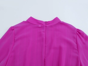 Dettaglio della schiena di un abito in chiffon rosa con cerniera invisibile e pieghe