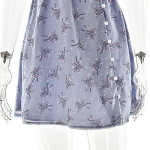 Gros plan sur la robe à fleurs bleue en mousseline avec boutons blancs et texture de tissu