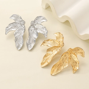 Detail of leaf earrings showing irregular wrinkled texture in gold and silver finish