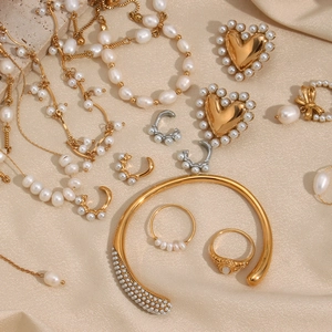 Flat lay of freshwater pearl jewelry set with gold necklaces and earrings on silk