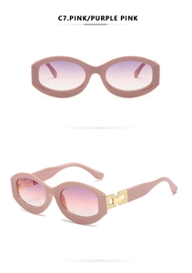 Detail view of pink oval thick frame sunglasses with gold chain link hinge and gradient lens