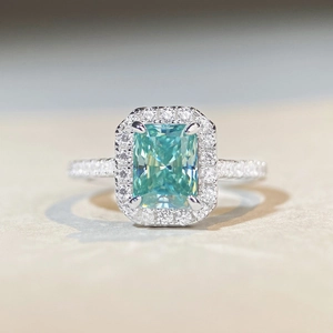 Macro detail of radiant cut mint green moissanite ring with halo diamonds