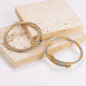 Men's two-tone cable wire twisted cuff bracelet with gold accents on stone display