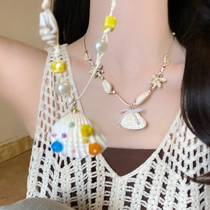 Close-up of summer starfish shell pendant necklace with pearls on a wax rope chain