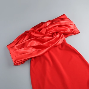 Close-up of the elegant red satin off-shoulder dress with ruched bodice and silky texture