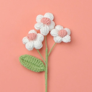 Close-up of handmade crochet puff flowers with white petals and pink centers
