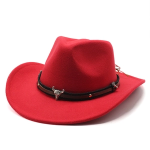 Detail of red wool cowboy hat with leather band and silver bull head ornament