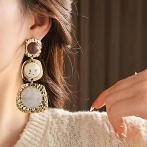 Close-up of vintage multi-layered resin earrings with marble pattern on a model