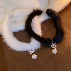 Vue détaillée de chokers en peluche noir et blanc avec flocon argenté et perle pendante