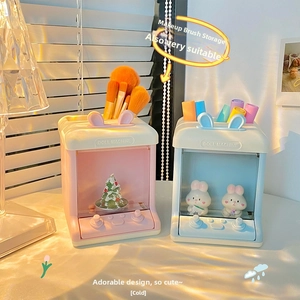 Close-up of pink and blue doll machine style desk organizers for pens and brushes