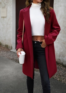 Street style view of a deep red wool coat with lapel collar and mid-length professional cut