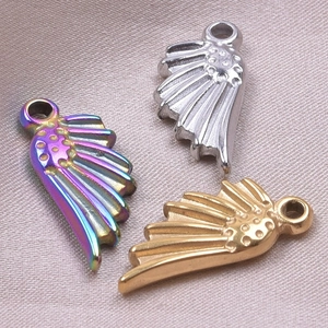 Vue détaillée des pendentifs en forme d'aile en acier inoxydable doré, argenté et arc-en-ciel