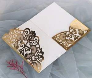 Detailed top view of white wedding invitation with elegant gold laser cut lace sleeve
