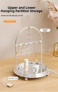 Detail of silver jewelry stand featuring tiered hooks and a mirror base tray organizer