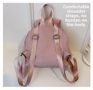 Detailed view of pink nylon backpack rear straps and adjustable metal buckles for comfort