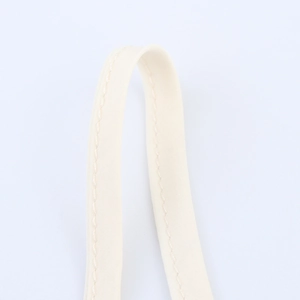 Close-up of beige vacation style two-piece set featuring reinforced canvas straps and stitching