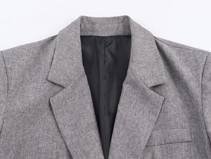 Detail shot of grey herringbone blazer showing lapel structure and smooth black lining