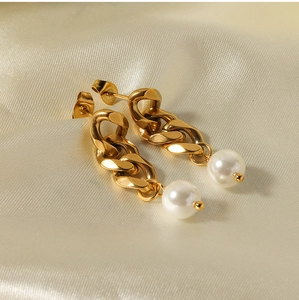 Detailed macro view of 18K gold-plated chain earrings with white pearls on silk fabric